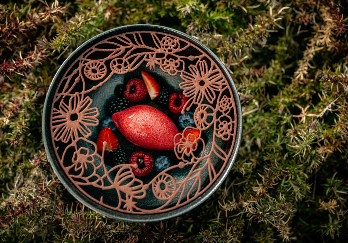 Beerensorbet mit Himbeeren, Brombeeren und Schokoladen-Blumendekor auf Schieferteller im Restaurant des Hotel Kronblick