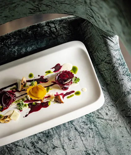 Kunstvoll angerichtete Rote-Bete-Vorspeise mit Kräuteröl und Tortellini im Gourmetrestaurant des Hotel Kronblick