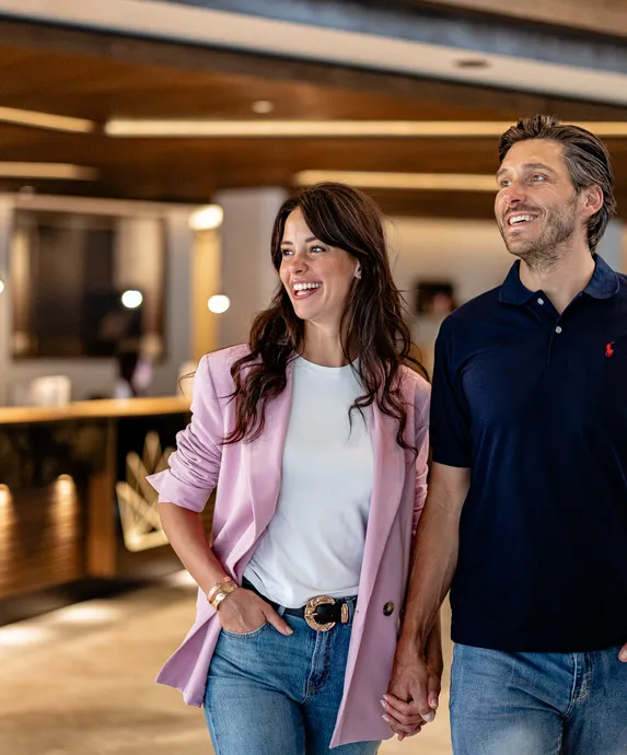 Verliebtes Paar Hand in Hand in der modernen Lobby des Hotel Kronblick im Pustertal, Südtirol